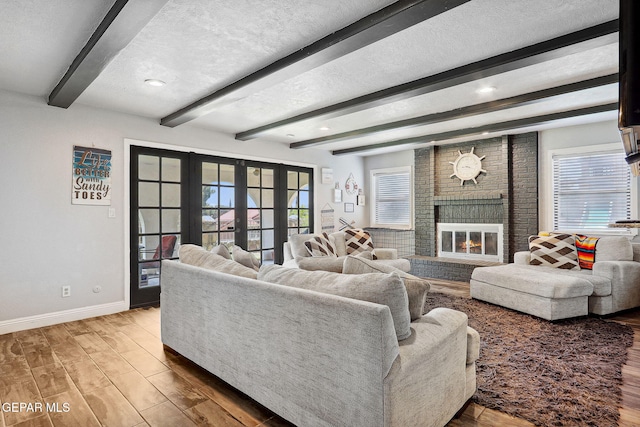 6008 Camino Alegre Dr, El Paso, TX 79912 - living area featuring baseboards, beamed ceiling, wood finished floors, plenty of natural light, and a fireplace