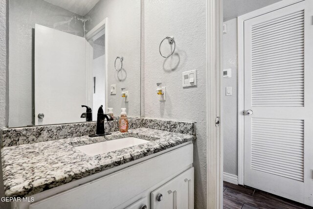 6008 Camino Alegre Dr, El Paso, TX 79912 - bathroom featuring vanity, wood finished floors, and a textured wall