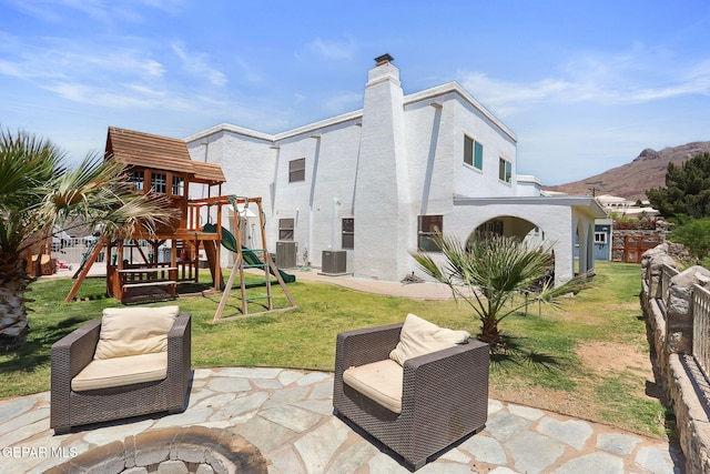 6008 Camino Alegre Dr, El Paso, TX 79912 - back of property with a playground, central AC, stucco siding, a mountain view, and a patio area