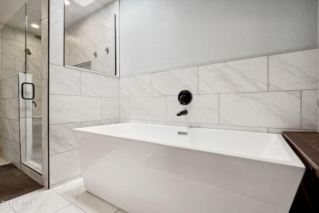 6008 Camino Alegre Dr, El Paso, TX 79912 - bathroom featuring a bath, a stall shower, and tile walls