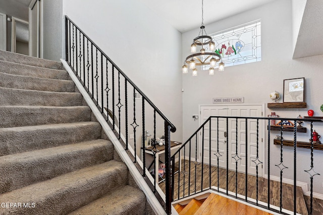 6008 Camino Alegre Dr, El Paso, TX 79912 - staircase with a chandelier, wood finished floors, and baseboards