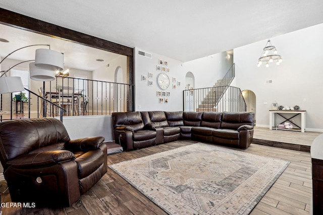 6008 Camino Alegre Dr, El Paso, TX 79912 - living room with arched walkways, a chandelier, wood finished floors, stairs, and baseboards