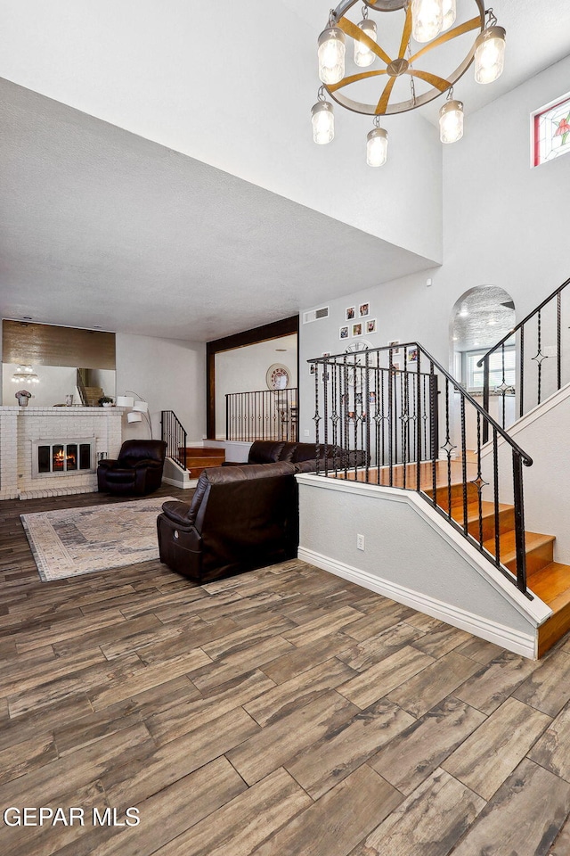 6008 Camino Alegre Dr, El Paso, TX 79912 - living room featuring wood finished floors, a towering ceiling, stairway, a chandelier, and baseboards