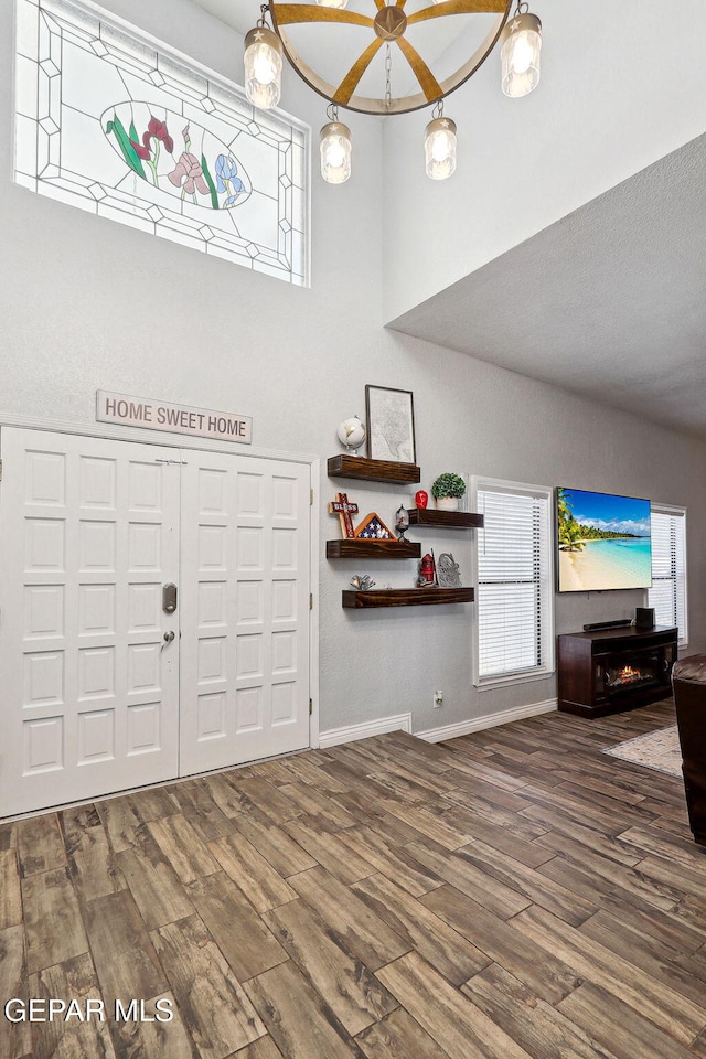 6008 Camino Alegre Dr, El Paso, TX 79912 - foyer featuring wood finished floors, a towering ceiling, and baseboards