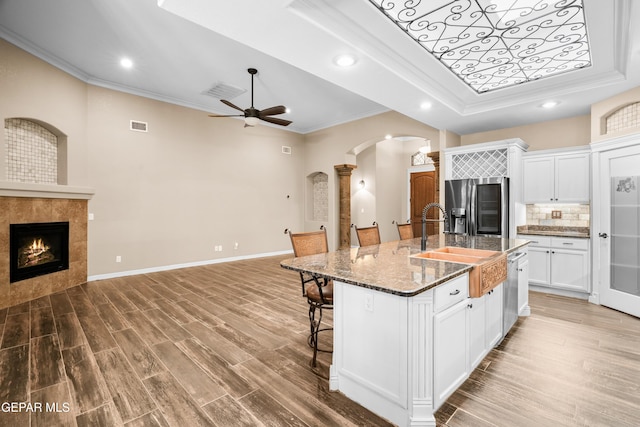 14624 Long Shadow Ave, El Paso, TX 79938 - kitchen with stainless steel appliances, arched walkways, crown molding, open floor plan, and a kitchen breakfast bar