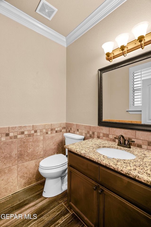 14624 Long Shadow Ave, El Paso, TX 79938 - bathroom with ornamental molding, tile walls, vanity, toilet, and a wainscoted wall