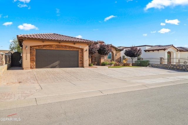 14624 Long Shadow Ave, El Paso, TX 79938 - mediterranean / spanish-style house featuring stucco siding, a gate, decorative driveway, a tiled roof, and a garage