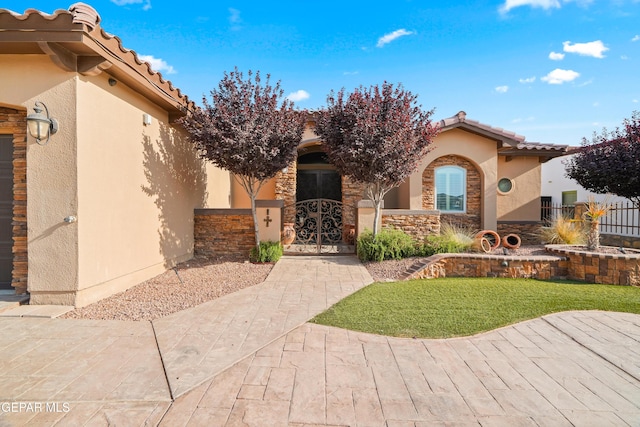 14624 Long Shadow Ave, El Paso, TX 79938 - doorway to property featuring stucco siding, a gate, stone siding, and a tile roof