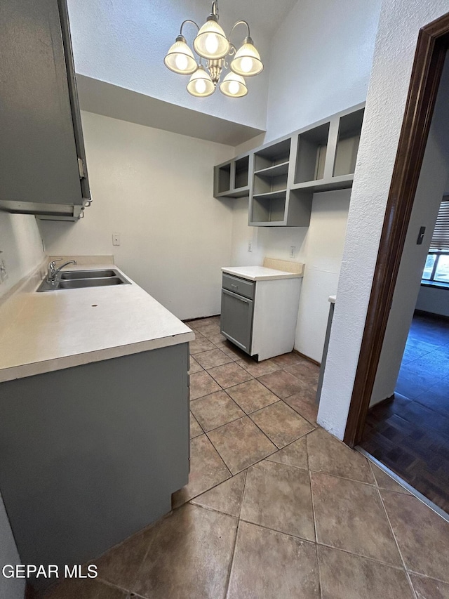 6061 Bridalveil Dr, El Paso, TX 79924 - kitchen with a sink, a chandelier, tile patterned floors, gray cabinetry, and light countertops