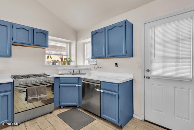 13324 Mitchell Dr, Horizon City, TX 79928 - kitchen with appliances with stainless steel finishes, blue cabinetry, lofted ceiling, wood tiled floors, and light countertops