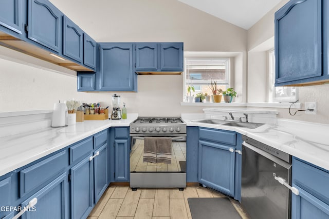 13324 Mitchell Dr, Horizon City, TX 79928 - kitchen with stainless steel appliances, blue cabinets, a sink, and vaulted ceiling