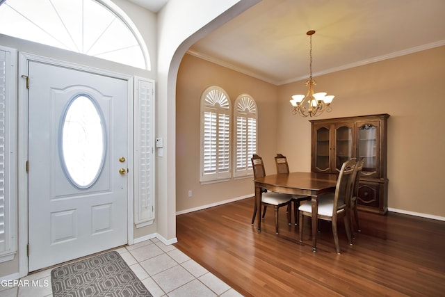 216 Desert Garden Dr, Santa Teresa, NM 88008 - foyer entrance featuring a chandelier, ornamental molding, arched walkways, light tile patterned floors, and baseboards
