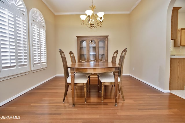 216 Desert Garden Dr, Santa Teresa, NM 88008 - dining area with arched walkways, light wood-type flooring, ornamental molding, a chandelier, and healthy amount of natural light