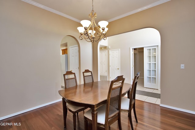 216 Desert Garden Dr, Santa Teresa, NM 88008 - dining room featuring arched walkways, crown molding, a chandelier, wood finished floors, and baseboards