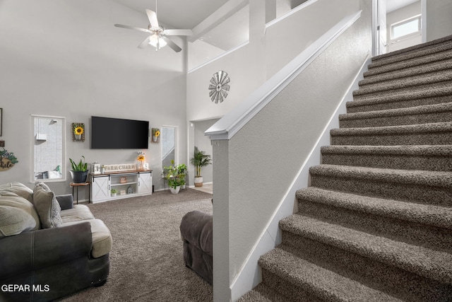 11562 Flor Gloriosa Dr, Socorro, TX 79927 - living area with stairway, a towering ceiling, carpet floors, a ceiling fan, and baseboards