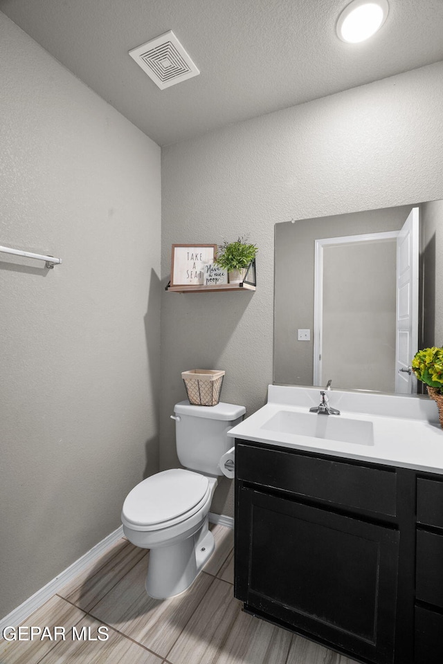 11562 Flor Gloriosa Dr, Socorro, TX 79927 - bathroom featuring toilet, vanity, wood finished floors, and baseboards