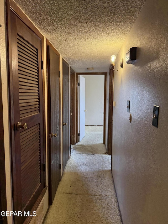 3910 Quasar Ct, El Paso, TX 79904 - hall featuring light carpet, a textured ceiling, and a textured wall