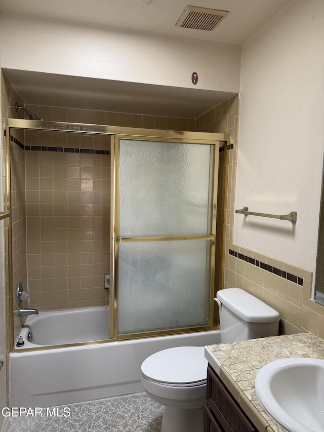 3910 Quasar Ct, El Paso, TX 79904 - bathroom with vanity, tile walls, toilet, enclosed tub / shower combo, and tile patterned floors