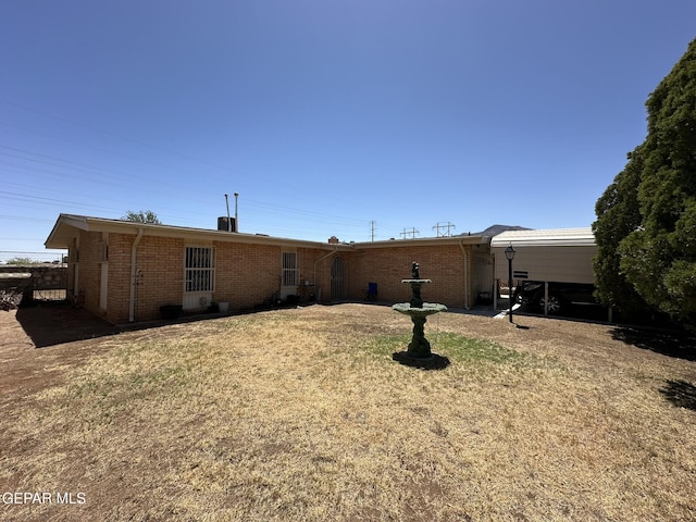5028 Sagittarius Ave, El Paso, TX 79924 - rear view of property featuring brick siding and a lawn