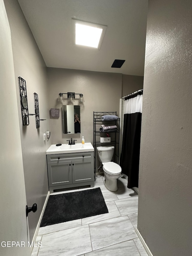 5028 Sagittarius Ave, El Paso, TX 79924 - bathroom featuring toilet, vanity, baseboards, and a shower with curtain