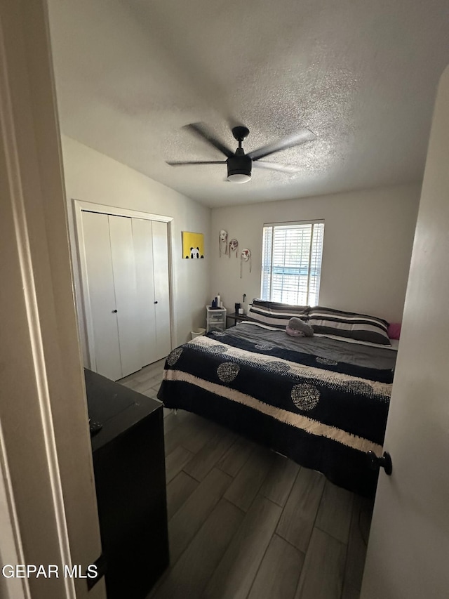 5028 Sagittarius Ave, El Paso, TX 79924 - bedroom with ceiling fan, a closet, wood finished floors, and a textured ceiling