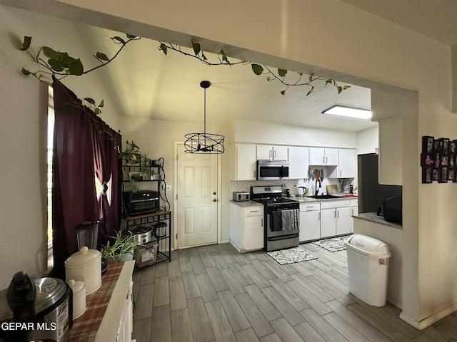5028 Sagittarius Ave, El Paso, TX 79924 - kitchen featuring appliances with stainless steel finishes, decorative backsplash, wood finished floors, and white cabinetry