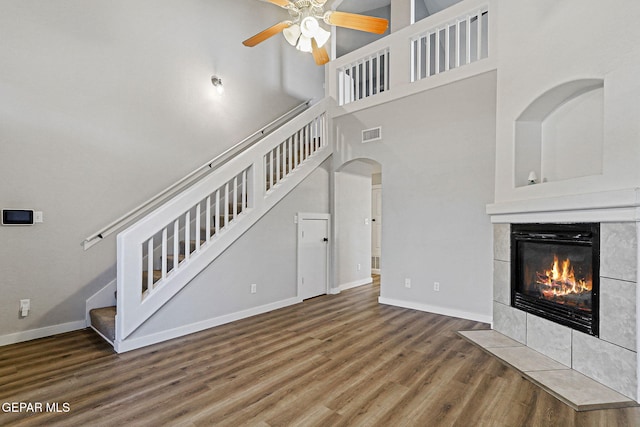 5965 Katelyn Gray Cir, El Paso, TX 79924 - unfurnished living room featuring stairway, wood finished floors, ceiling fan, a tile fireplace, and baseboards