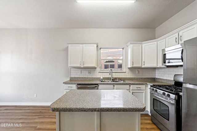 5965 Katelyn Gray Cir, El Paso, TX 79924 - kitchen with stainless steel appliances, a sink, tasteful backsplash, and dark wood-type flooring