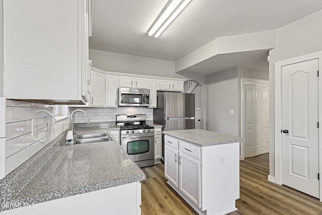 5965 Katelyn Gray Cir, El Paso, TX 79924 - kitchen featuring stainless steel appliances, a sink, white cabinets, decorative backsplash, and a center island