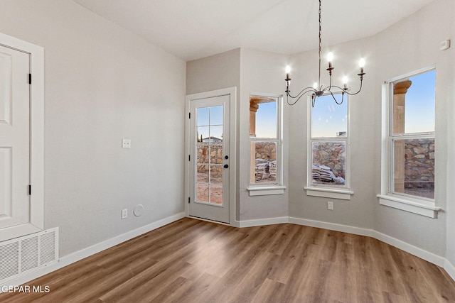5965 Katelyn Gray Cir, El Paso, TX 79924 - unfurnished dining area featuring wood finished floors, a chandelier, plenty of natural light, and baseboards