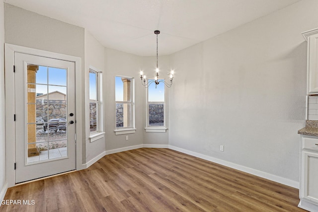 5965 Katelyn Gray Cir, El Paso, TX 79924 - unfurnished dining area with a chandelier, wood finished floors, and baseboards