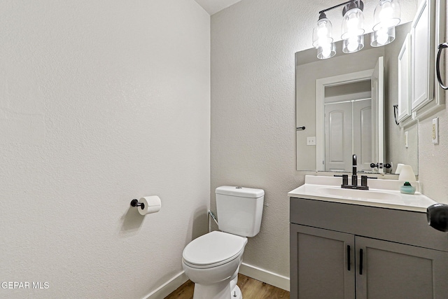 5965 Katelyn Gray Cir, El Paso, TX 79924 - bathroom with toilet, vanity, wood finished floors, baseboards, and a textured wall