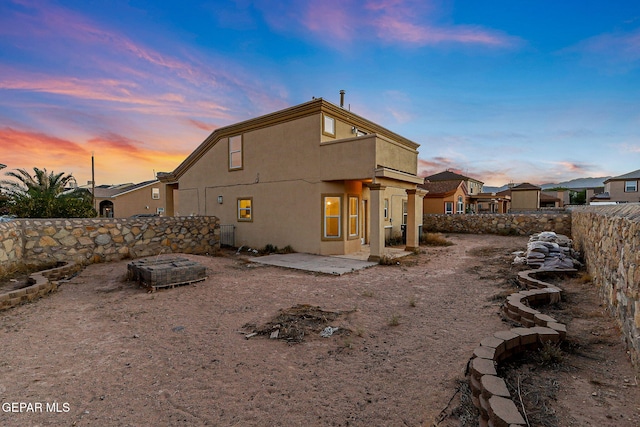 5965 Katelyn Gray Cir, El Paso, TX 79924 - back of house at dusk with a patio, stucco siding, and a balcony