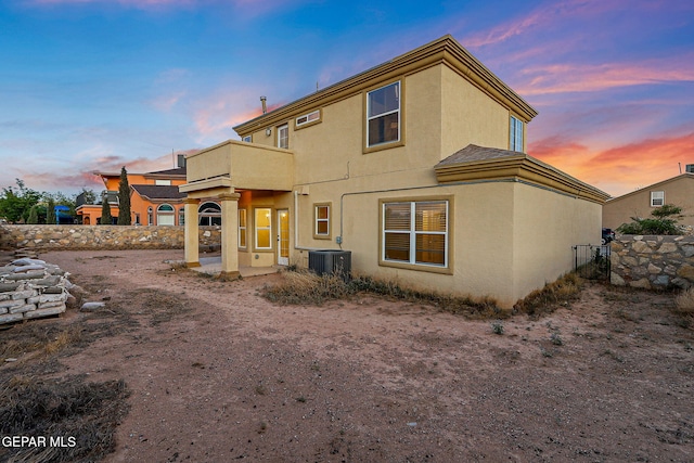 5965 Katelyn Gray Cir, El Paso, TX 79924 - back of house at dusk with stucco siding, central AC unit, and a balcony