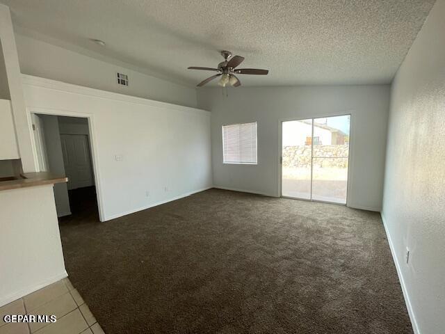 12501 Sombra Fuerte Dr, El Paso, TX 79938 - unfurnished living room with a ceiling fan, carpet, a textured ceiling, and lofted ceiling