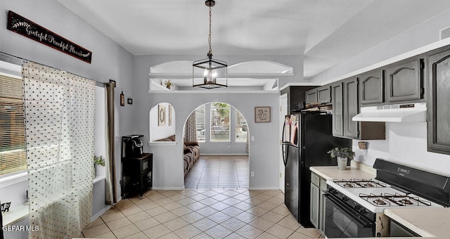 14156 Warren Belin Dr, Horizon City, TX 79928 - kitchen with gas range oven, under cabinet range hood, light countertops, light tile patterned floors, and hanging light fixtures