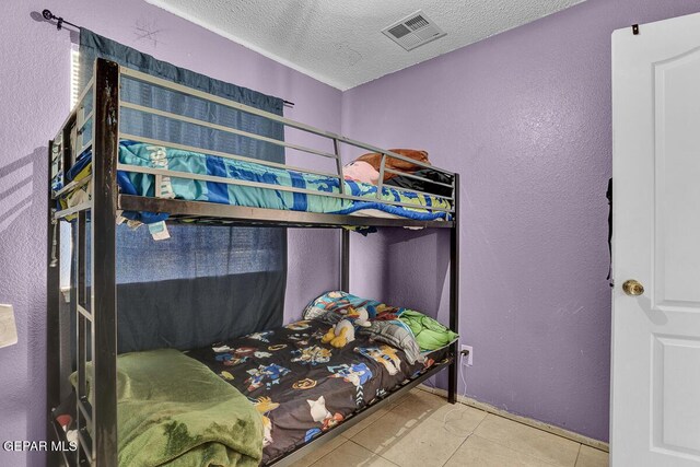 14156 Warren Belin Dr, Horizon City, TX 79928 - bedroom with a textured ceiling, tile patterned flooring, a textured wall, and baseboards