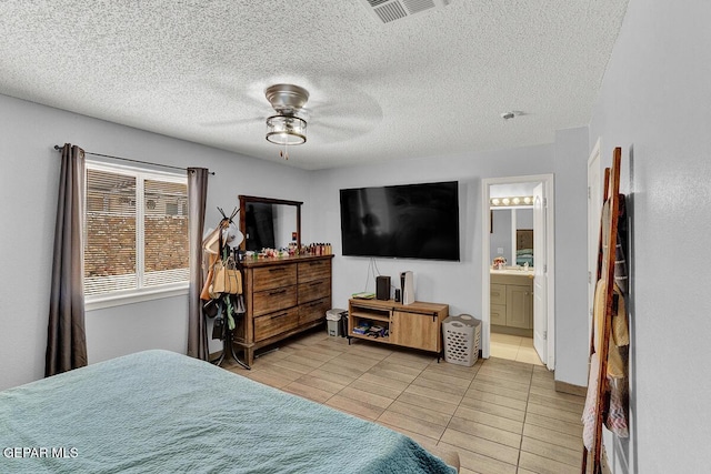 14156 Warren Belin Dr, Horizon City, TX 79928 - bedroom with light tile patterned floors, ensuite bath, a ceiling fan, and a textured ceiling