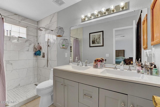 14156 Warren Belin Dr, Horizon City, TX 79928 - ensuite bathroom featuring double vanity, a tile shower, toilet, and tile patterned flooring