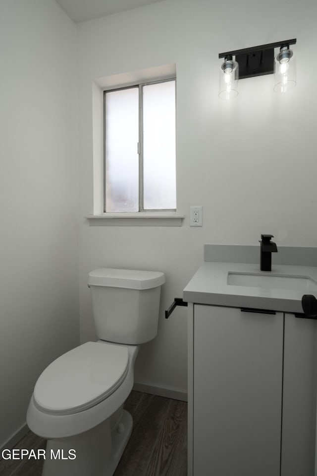 6608 Los Altos Dr, El Paso, TX 79912 - bathroom with vanity, wood finished floors, toilet, and baseboards