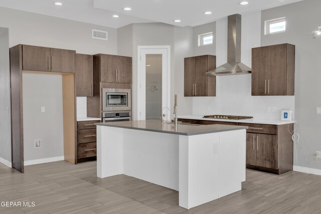 2174 Enchanted Crest Dr, El Paso, TX 79911 - kitchen with wall chimney exhaust hood, stainless steel appliances, baseboards, a kitchen island with sink, and recessed lighting