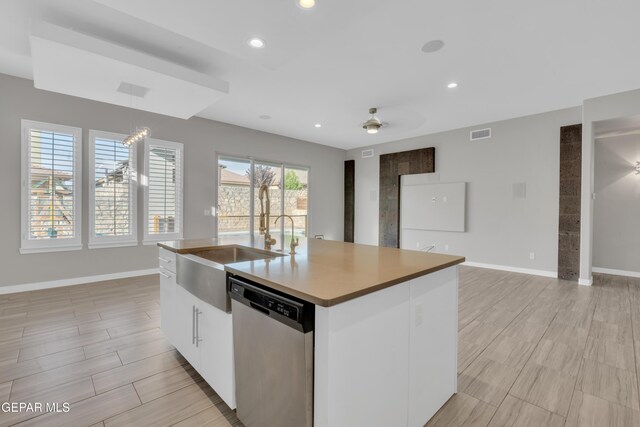 2174 Enchanted Crest Dr, El Paso, TX 79911 - kitchen with dishwasher, a ceiling fan, baseboards, a center island with sink, and white cabinets