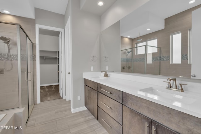 2174 Enchanted Crest Dr, El Paso, TX 79911 - full bathroom with a shower stall, double vanity, a spacious closet, baseboards, and recessed lighting