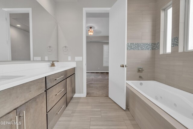 2174 Enchanted Crest Dr, El Paso, TX 79911 - bathroom featuring a tub with jets, double vanity, and baseboards