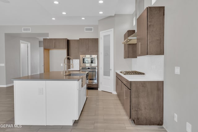 2174 Enchanted Crest Dr, El Paso, TX 79911 - kitchen with appliances with stainless steel finishes, backsplash, recessed lighting, light wood-style flooring, and a center island with sink