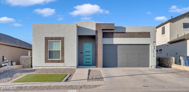 2174 Enchanted Crest Dr, El Paso, TX 79911 - contemporary house featuring driveway, an attached garage, and stucco siding
