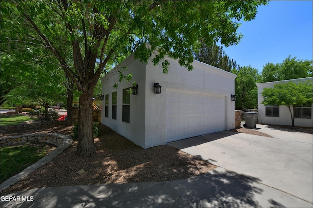 4490 Shadow Willow Dr, El Paso, TX 79922 - view of side of property with stucco siding, concrete driveway, and a garage