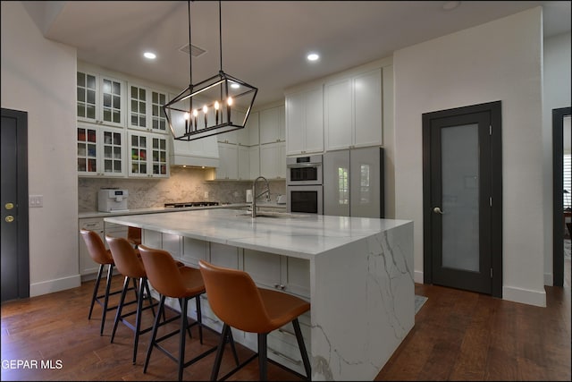 4490 Shadow Willow Dr, El Paso, TX 79922 - kitchen with dark wood-style floors, backsplash, appliances with stainless steel finishes, a sink, and white cabinets