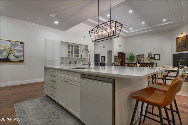 4490 Shadow Willow Dr, El Paso, TX 79922 - kitchen featuring white dishwasher, a sink, open floor plan, a kitchen island with sink, and light stone counters