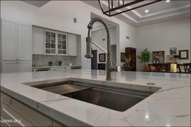 4490 Shadow Willow Dr, El Paso, TX 79922 - kitchen with light stone countertops, backsplash, glass insert cabinets, recessed lighting, and a sink